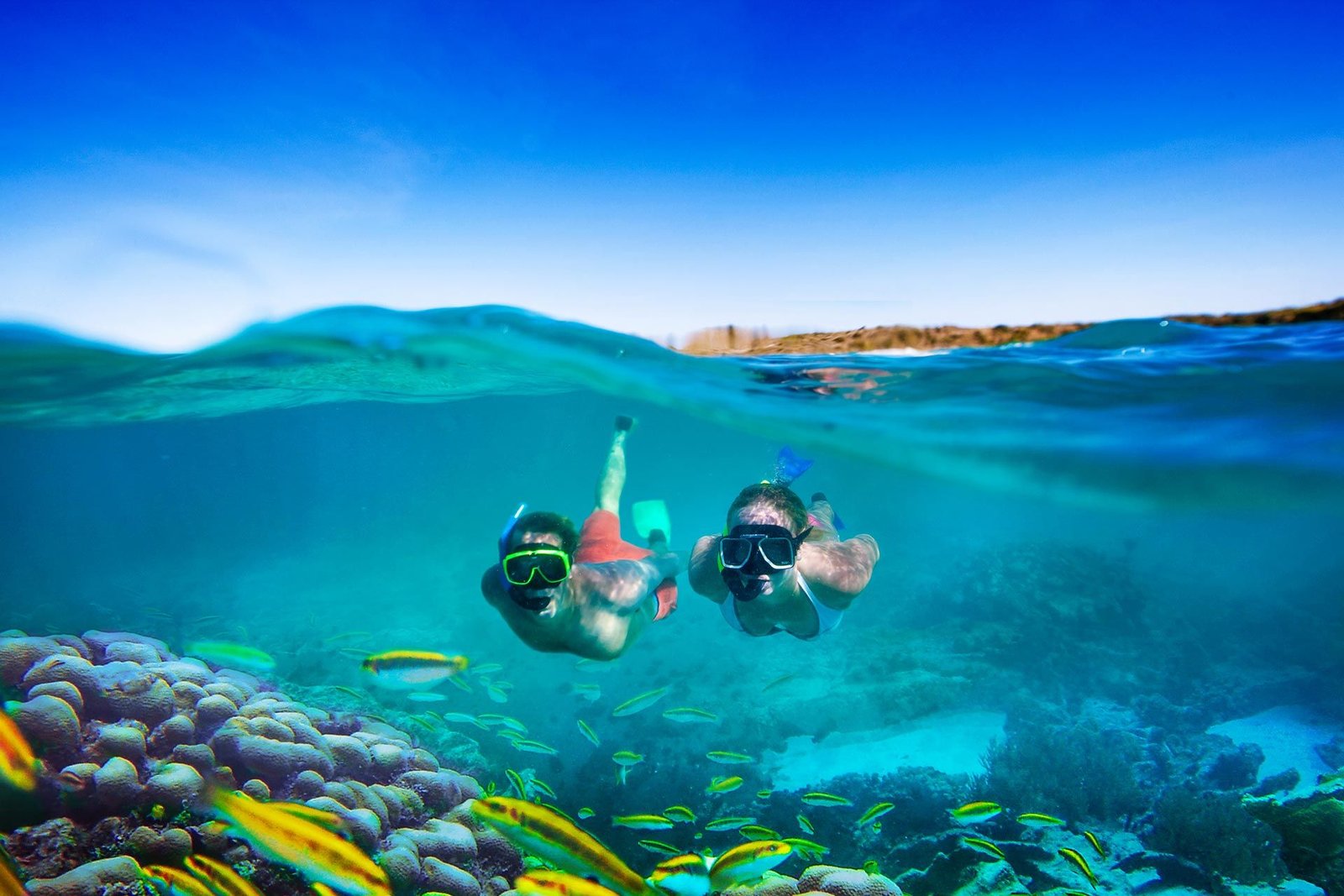 two people snorkeling but camera is also showing above water level