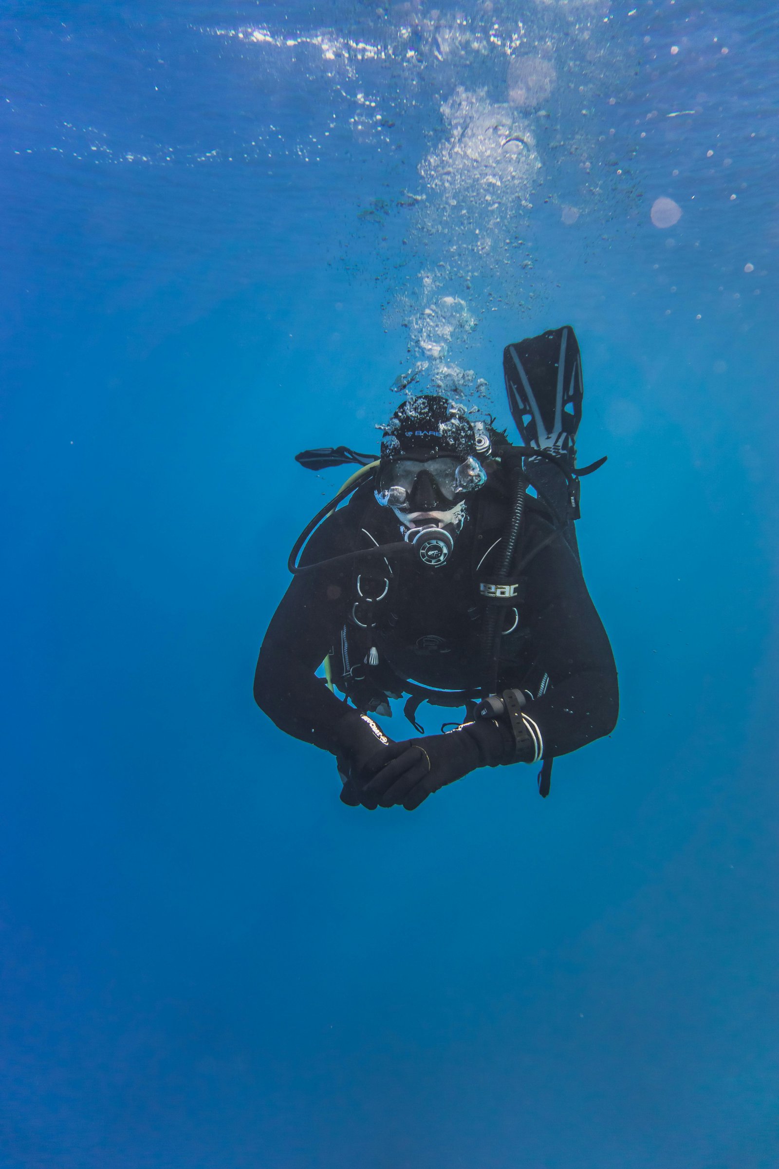 diver looking at camera while diving in deep blue ocean